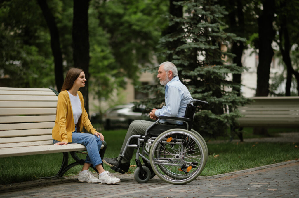 Daughter and disabled father resting on a bench
